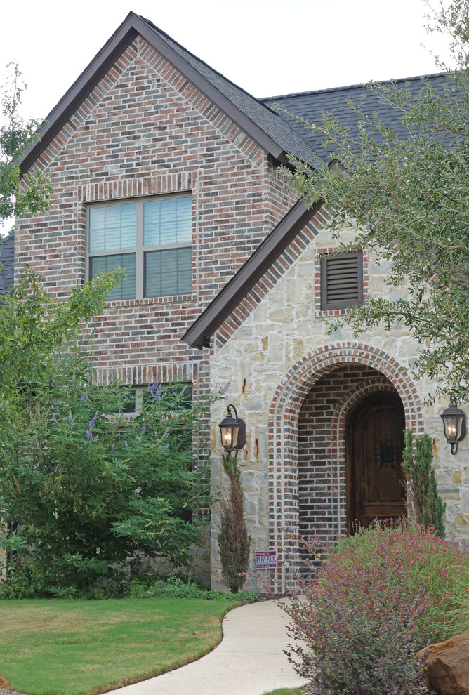 Inspiration for a large timeless red two-story mixed siding exterior home remodel in Dallas with a shingle roof