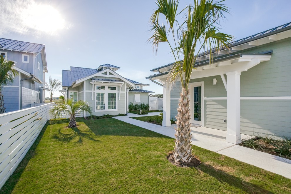 Стильный дизайн: маленький, одноэтажный, зеленый частный загородный дом в морском стиле с облицовкой из ЦСП, двускатной крышей и металлической крышей для на участке и в саду - последний тренд
