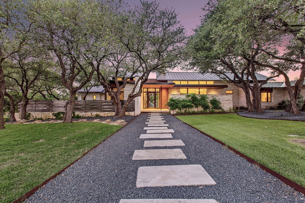 Modernes Einfamilienhaus mit Steinfassade, beiger Fassadenfarbe, Pultdach und Blechdach in Austin