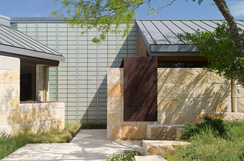 Idee per la facciata di una casa ampia beige contemporanea a piani sfalsati con rivestimento in pietra e tetto piano