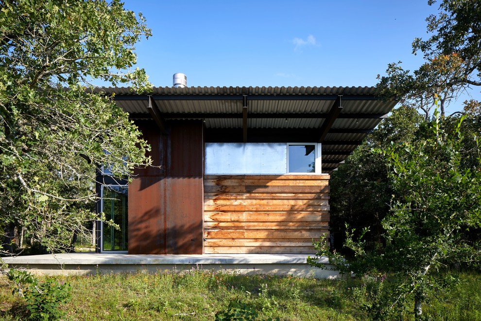 Inspiration pour une façade de maison traditionnelle de plain-pied avec un revêtement mixte, un toit en appentis et un toit en métal.