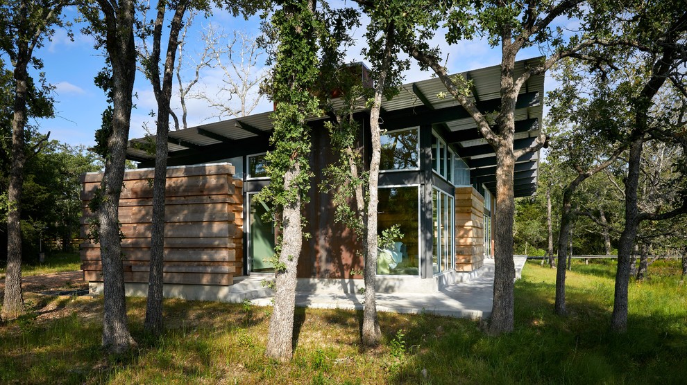 Свежая идея для дизайна: одноэтажный частный загородный дом среднего размера в современном стиле с односкатной крышей и металлической крышей - отличное фото интерьера