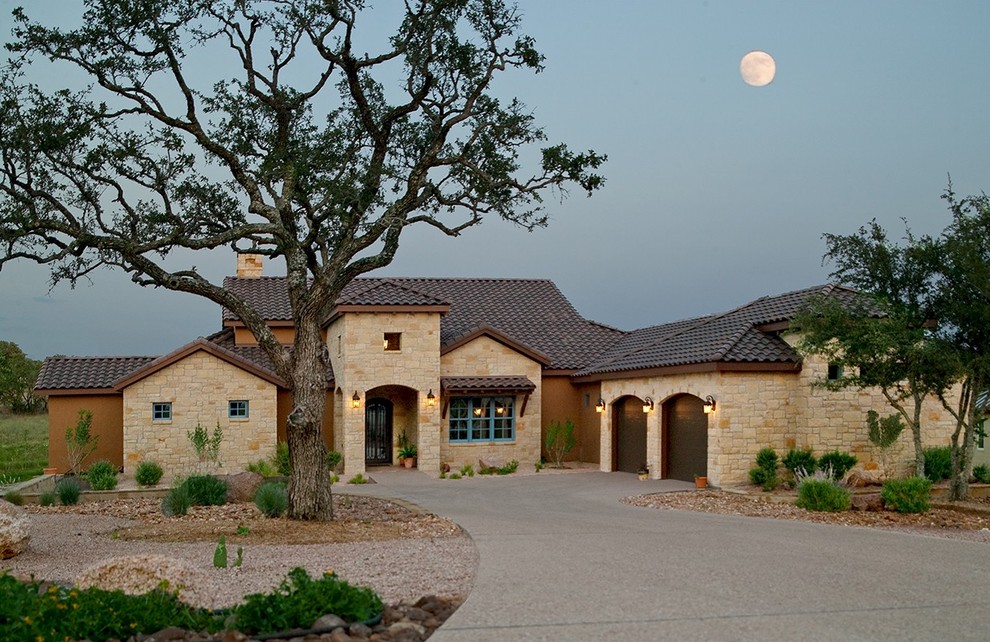 This is an example of a mediterranean house exterior in Austin with mixed cladding and a tiled roof.