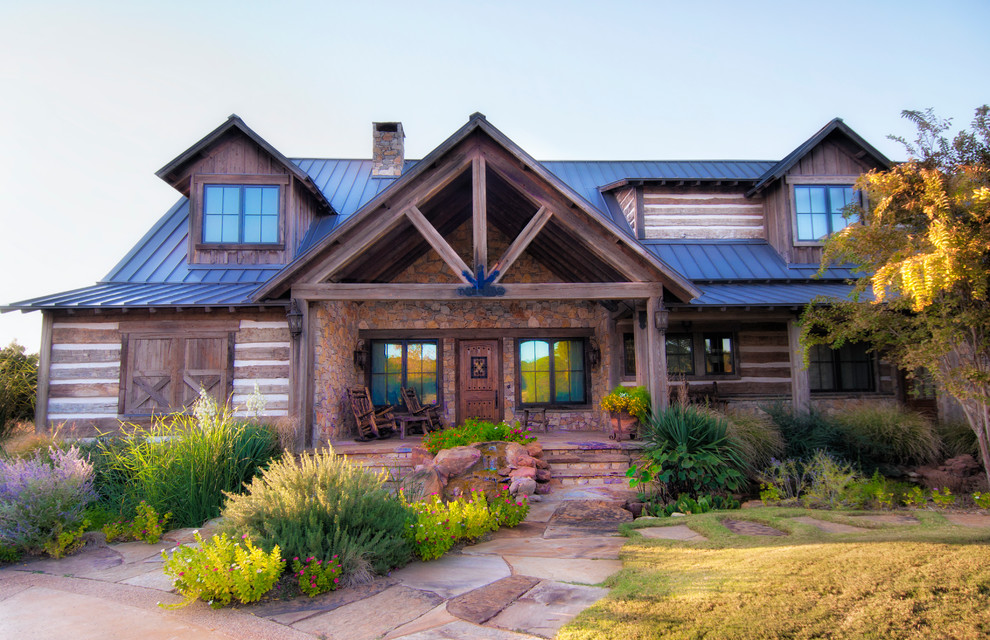 Inspiration for a rustic two floor house exterior in Salt Lake City with wood cladding.