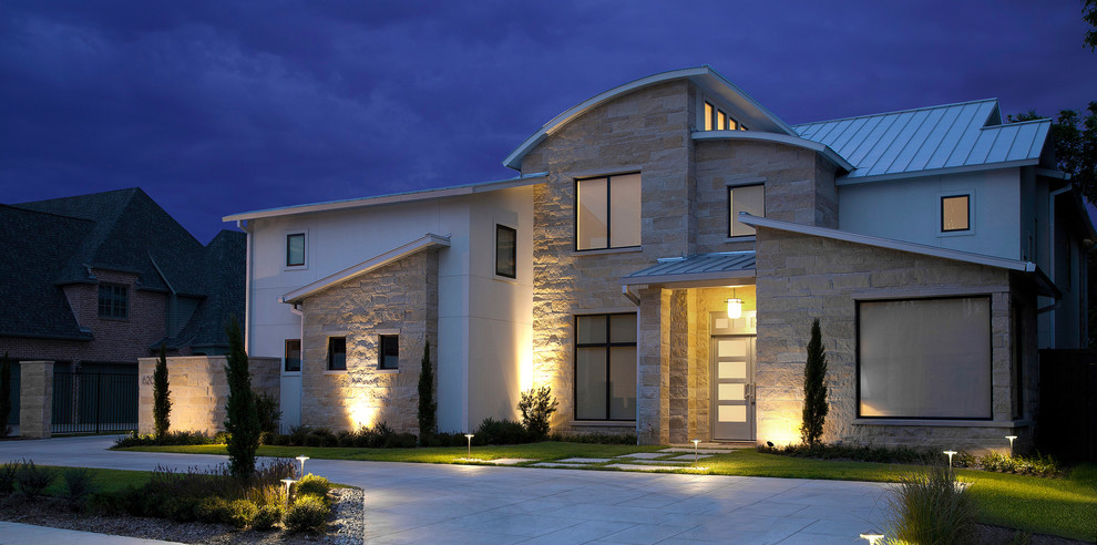 Réalisation d'une grande façade de maison beige minimaliste en pierre à un étage avec un toit en métal.