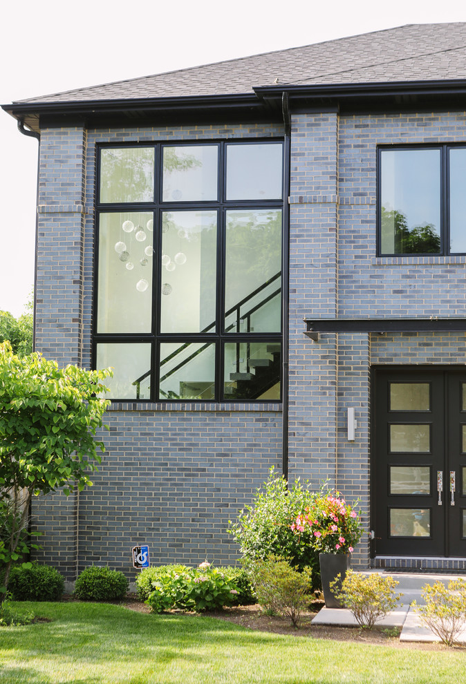 Inspiration pour une grande façade de maison multicolore minimaliste en brique à un étage avec un toit à quatre pans et un toit en shingle.