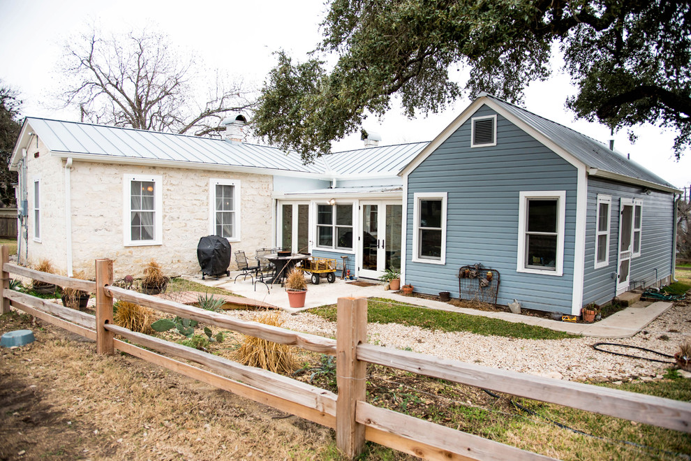 Mittelgroßes, Einstöckiges Country Einfamilienhaus mit Mix-Fassade, blauer Fassadenfarbe, Satteldach und Blechdach in Austin