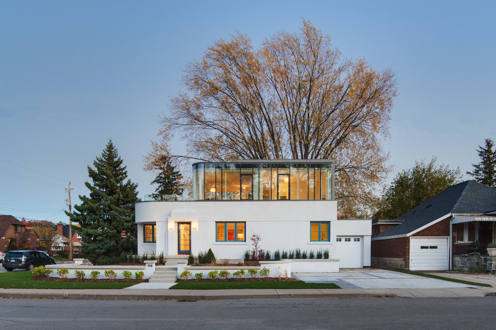 Design ideas for a white contemporary two floor house exterior in Toronto with a flat roof.