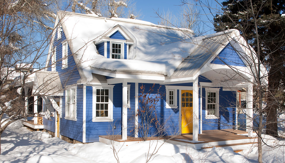 Immagine della facciata di una casa blu classica a due piani di medie dimensioni con rivestimento in vinile e tetto a capanna