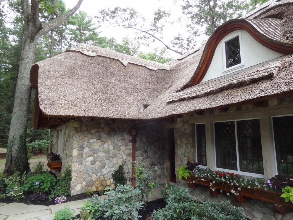 Стильный дизайн: двухэтажный, серый дом среднего размера в стиле фьюжн с облицовкой из камня и вальмовой крышей - последний тренд
