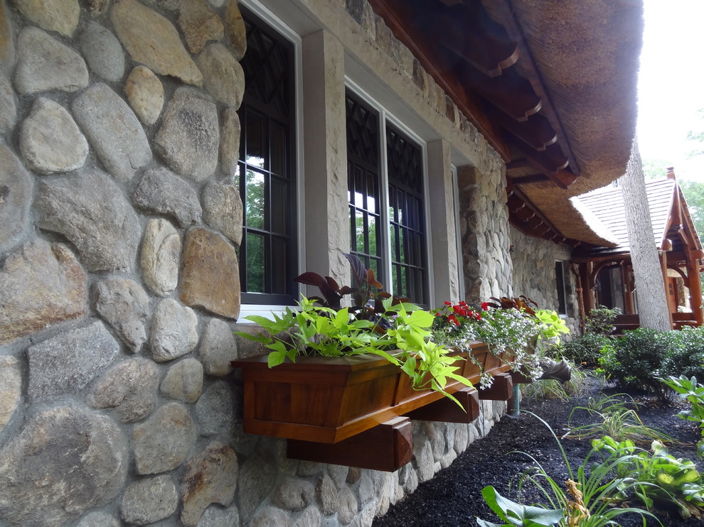 Пример оригинального дизайна: двухэтажный, серый дом среднего размера в стиле фьюжн с облицовкой из камня и вальмовой крышей