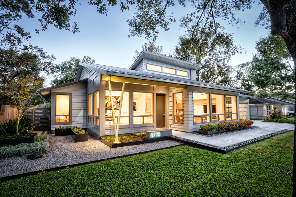 Пример оригинального дизайна: одноэтажный, серый частный загородный дом в стиле ретро с облицовкой из ЦСП, вальмовой крышей и металлической крышей
