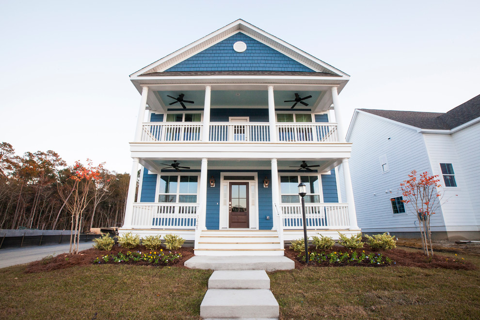 Esempio della facciata di una casa blu classica a due piani con rivestimento con lastre in cemento
