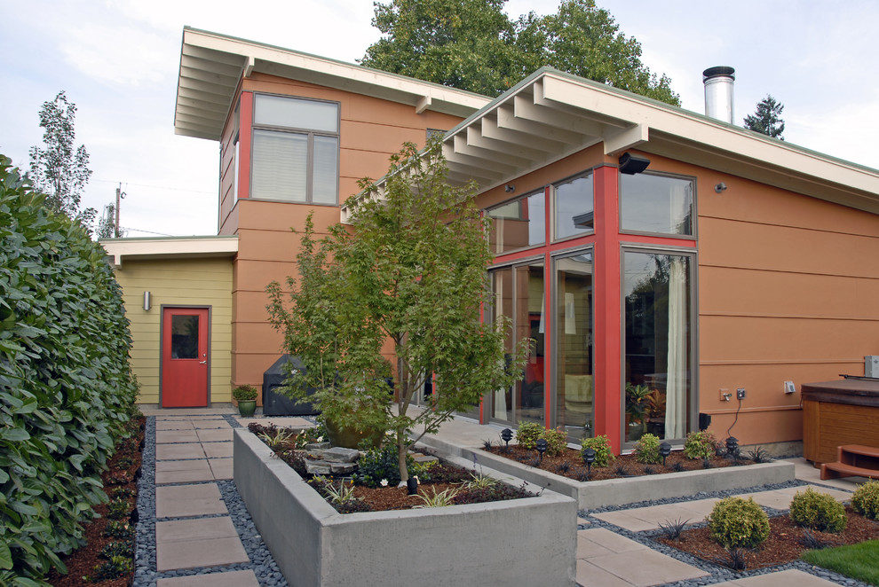 Exemple d'une façade de maison orange tendance à un étage.