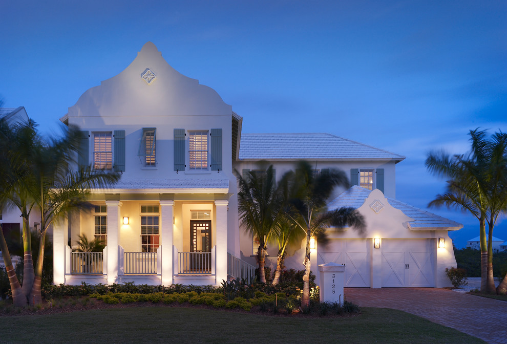 Medium sized and white world-inspired two floor detached house in Tampa with mixed cladding, a hip roof and a shingle roof.