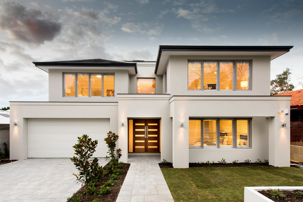 Cette image montre une façade de maison blanche design à un étage avec un toit à quatre pans.