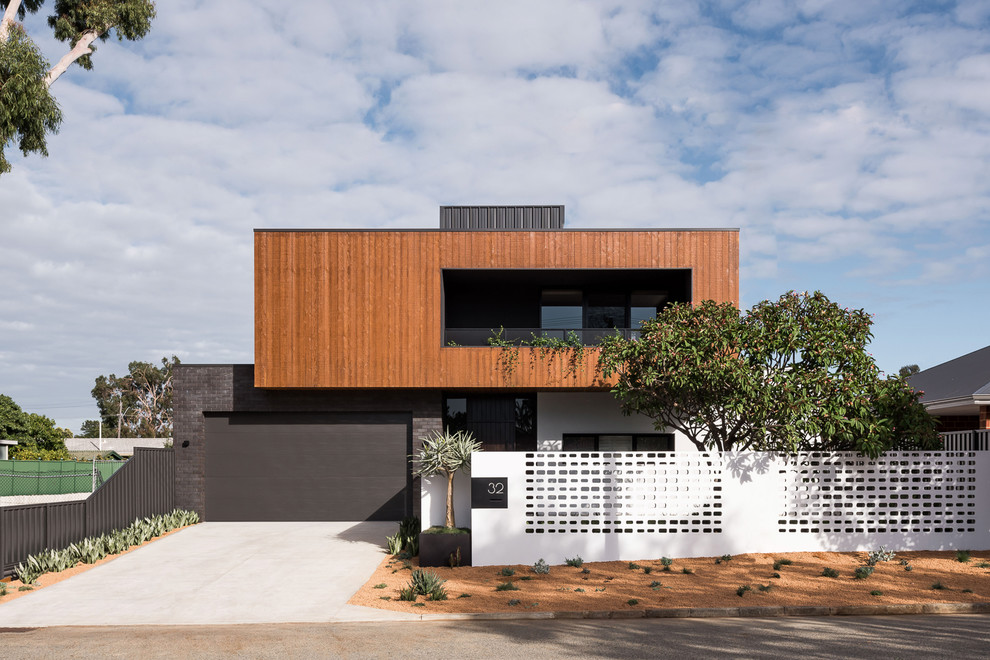Cette photo montre une façade de maison marron tendance à un étage avec un revêtement mixte et un toit plat.