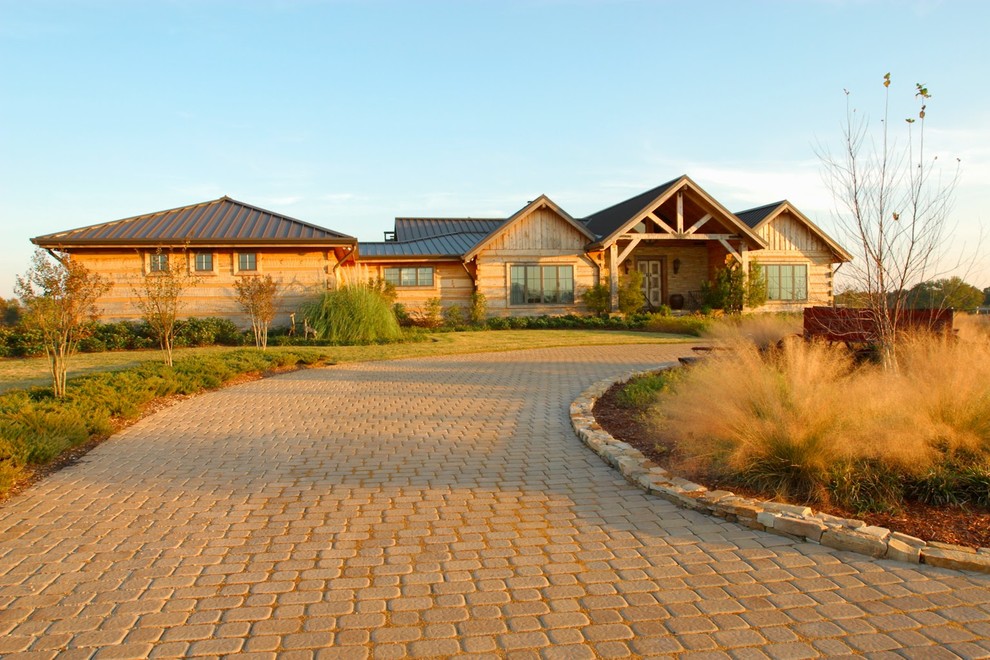 Imagen de fachada marrón rural grande de dos plantas con revestimiento de madera y tejado a dos aguas