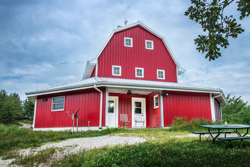 Mittelgroßes, Dreistöckiges Landhaus Einfamilienhaus mit Metallfassade, roter Fassadenfarbe und Mansardendach in Omaha