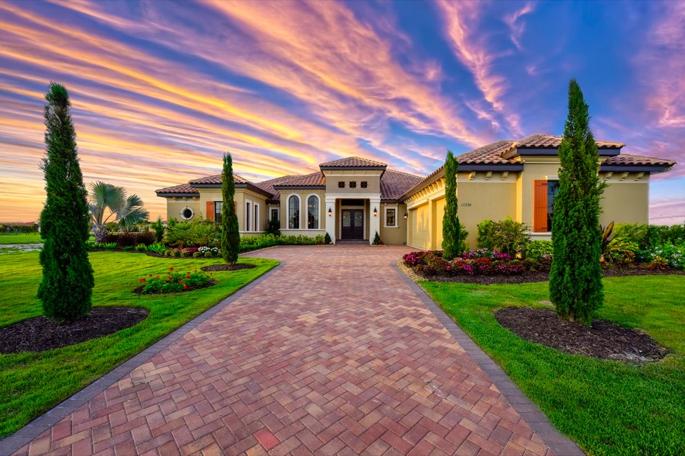 Example of a huge tuscan beige one-story stucco exterior home design in Tampa