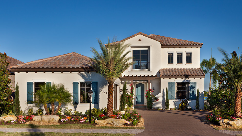 Großes, Zweistöckiges Mediterranes Haus mit Putzfassade und beiger Fassadenfarbe in Tampa