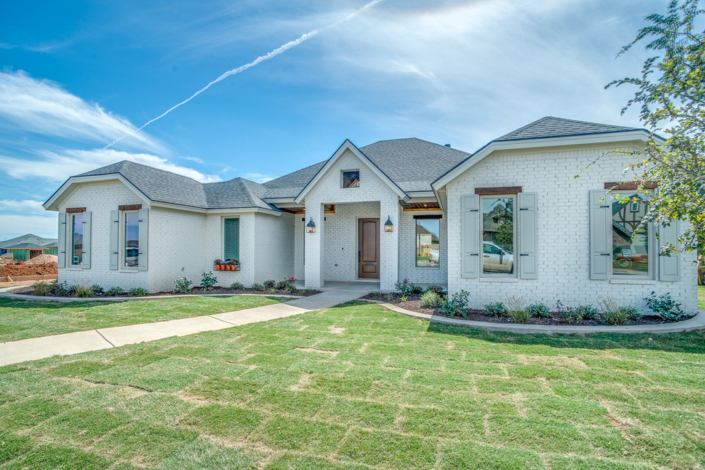 Inspiration for a medium sized and white modern bungalow brick detached house in Austin with a half-hip roof and a shingle roof.