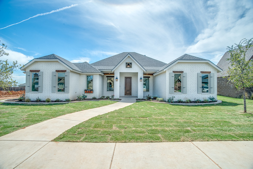 Mittelgroßes, Einstöckiges Country Einfamilienhaus mit Backsteinfassade, weißer Fassadenfarbe, Halbwalmdach und Schindeldach in Austin