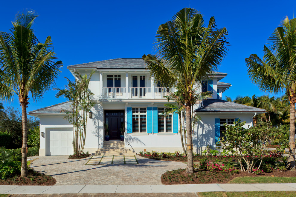 Großes, Zweistöckiges Haus mit Putzfassade, weißer Fassadenfarbe und Walmdach in Miami