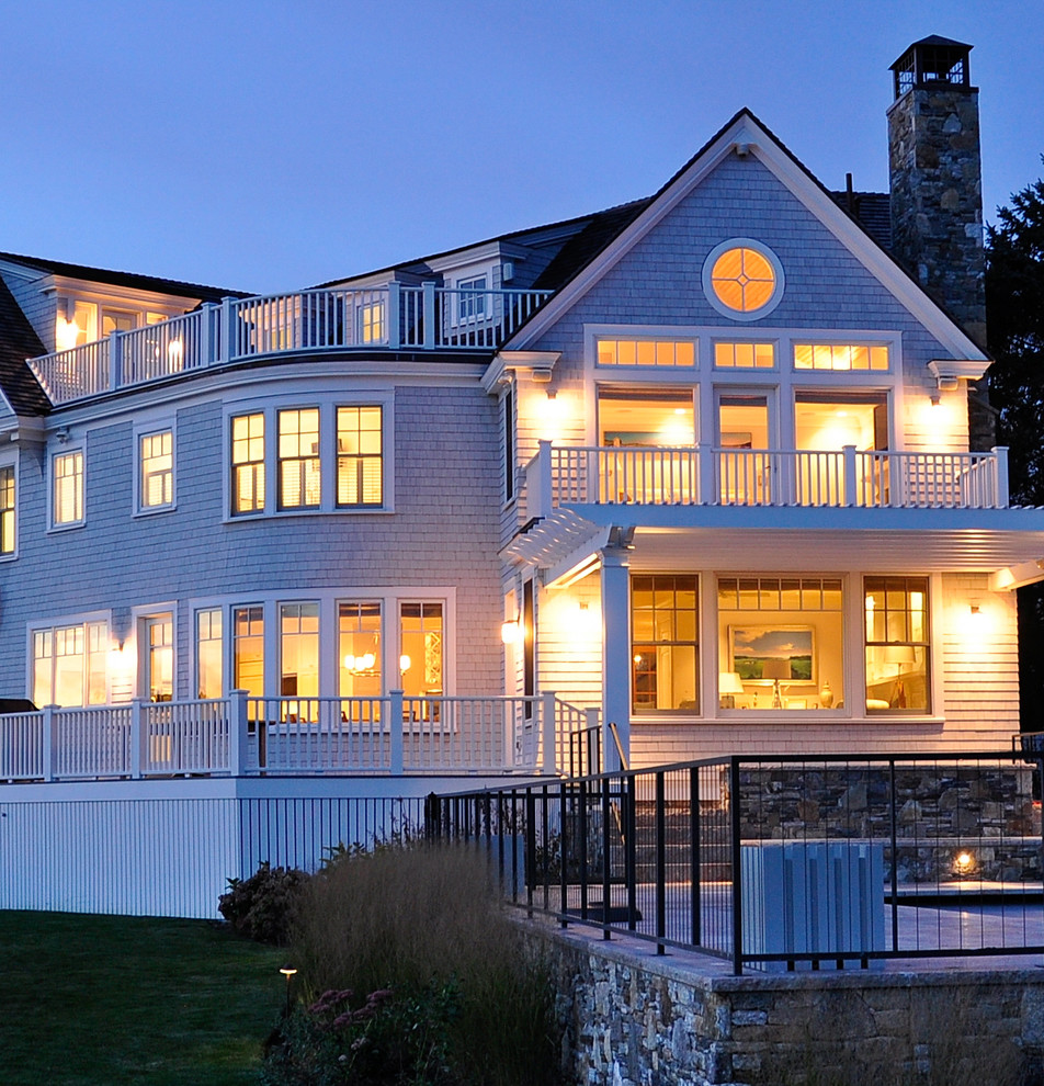Идея дизайна: трехэтажный, деревянный, серый, большой частный загородный дом в морском стиле с полувальмовой крышей и крышей из гибкой черепицы