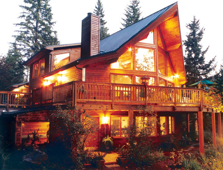 Large and brown rustic two floor house exterior in Vancouver with wood cladding and a pitched roof.