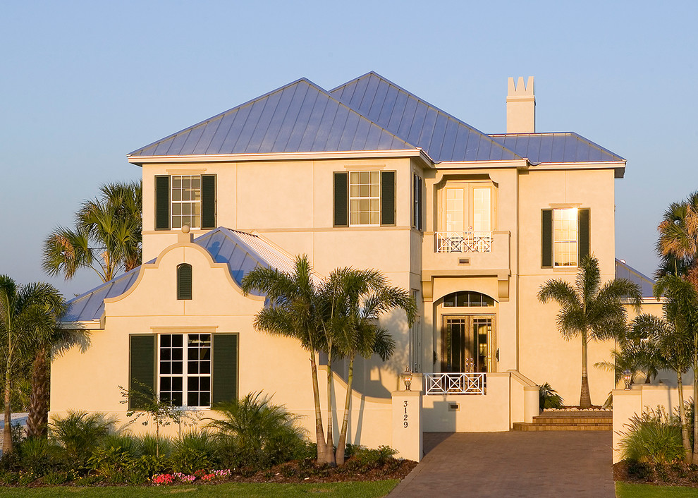 This is an example of an expansive and beige world-inspired two floor render house exterior in Tampa.