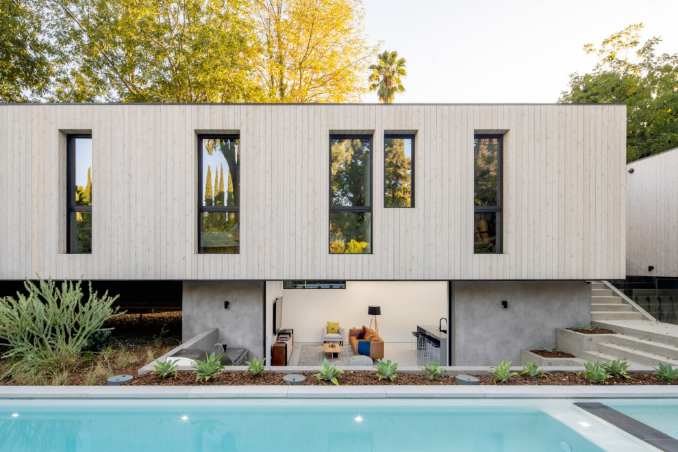 Ejemplo de fachada de casa beige vintage con revestimiento de madera y tejado plano