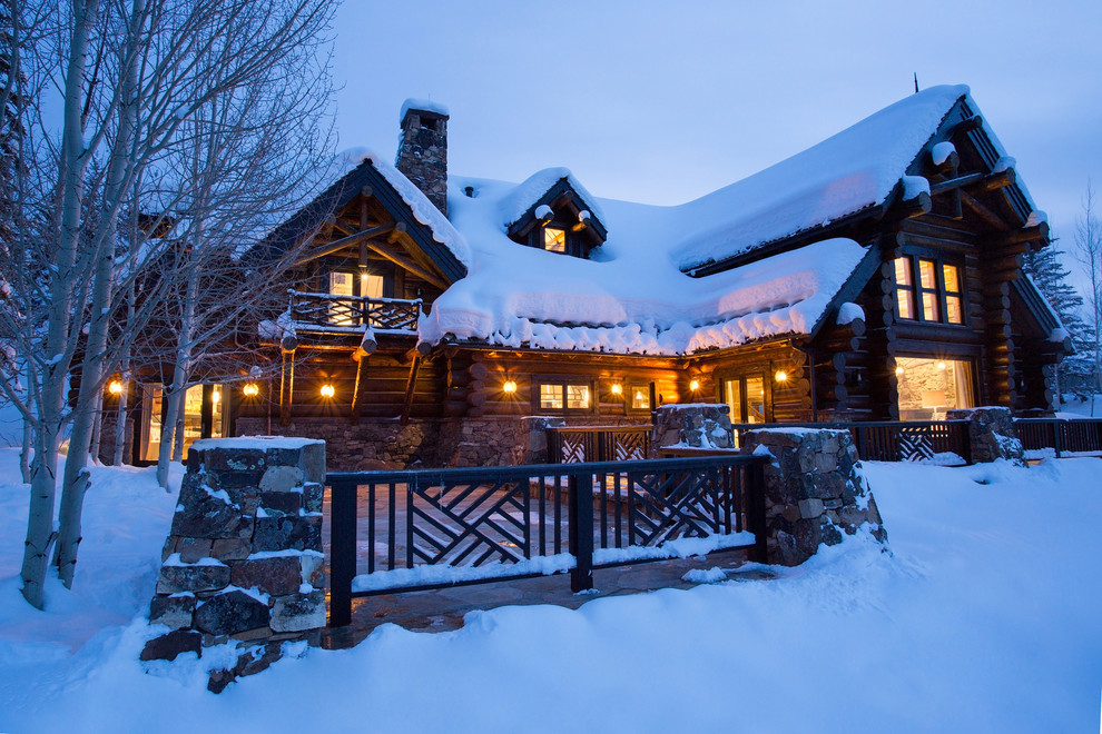 Example of a huge mountain style three-story wood exterior home design in Denver with a clipped gable roof