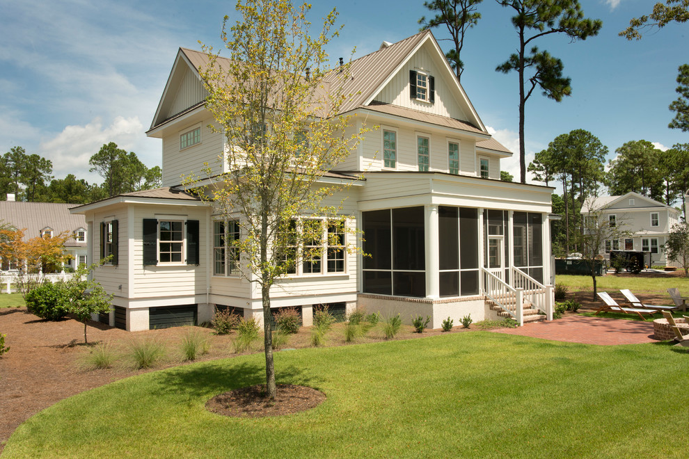 Inspiration pour une façade de maison blanche traditionnelle en bois de taille moyenne et à un étage avec un toit en métal.