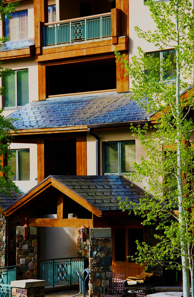 Imagen de fachada de casa beige rural grande de dos plantas con revestimientos combinados y tejado de teja de barro
