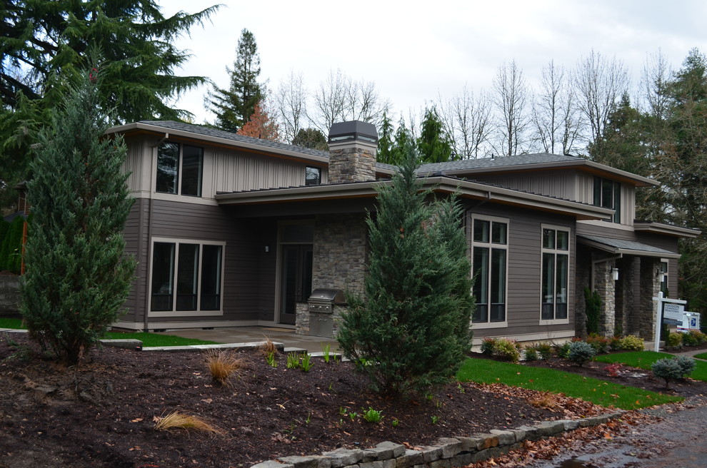 Foto de fachada gris contemporánea grande de dos plantas con revestimientos combinados y tejado a cuatro aguas