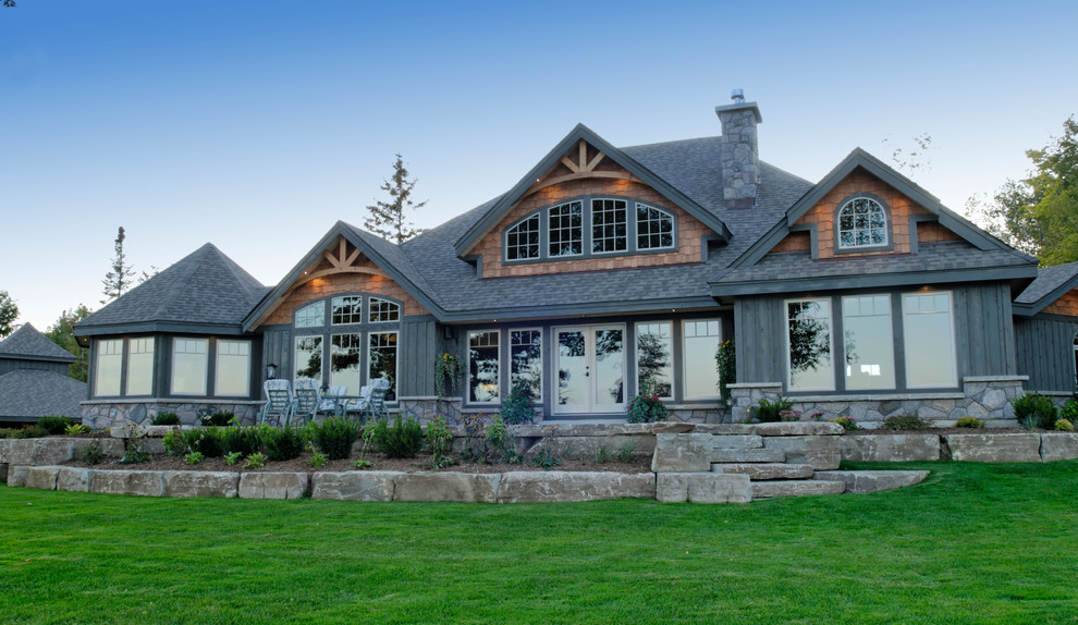 Example of a large arts and crafts gray two-story wood exterior home design in Vancouver with a hip roof