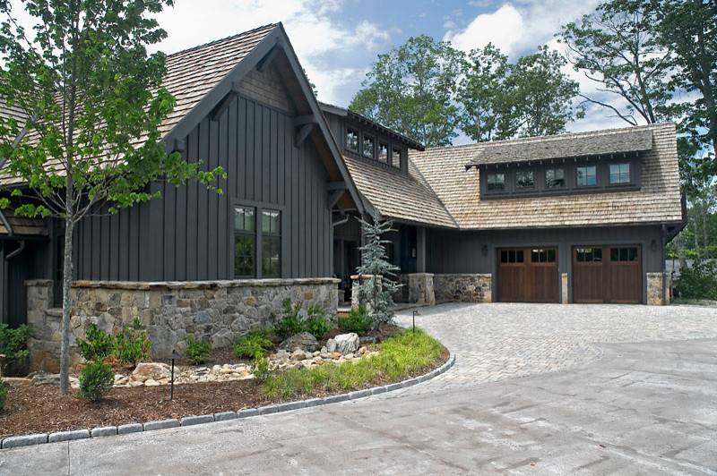 Imagen de fachada de casa negra contemporánea grande de dos plantas con revestimientos combinados, tejado a cuatro aguas y tejado de teja de madera