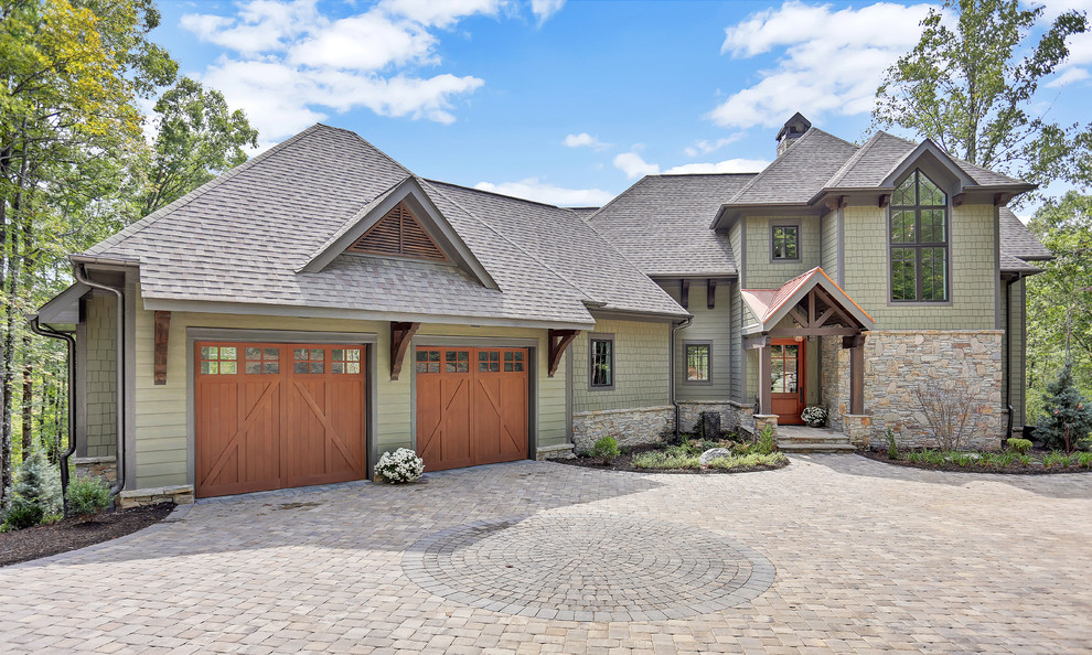 Mountain style green two-story wood house exterior photo in Other with a hip roof and a shingle roof
