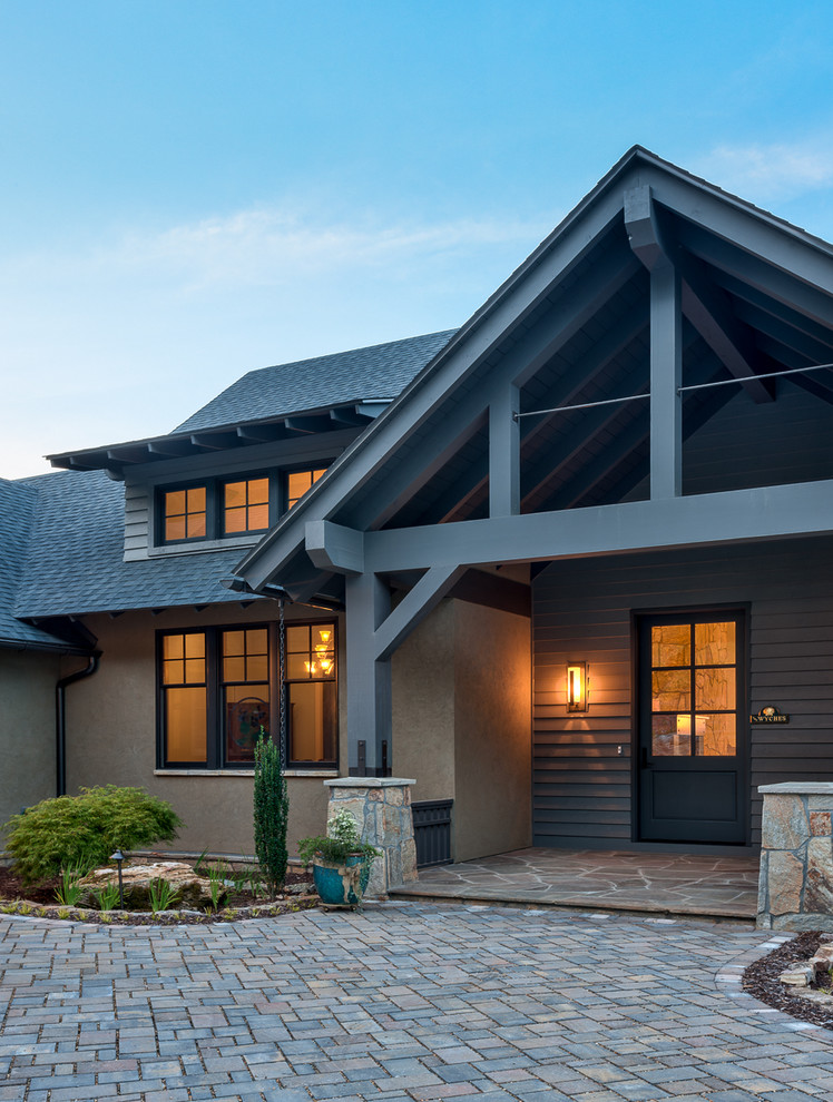 Imagen de fachada de casa marrón de estilo americano grande de dos plantas con revestimientos combinados, tejado a dos aguas y tejado de teja de madera