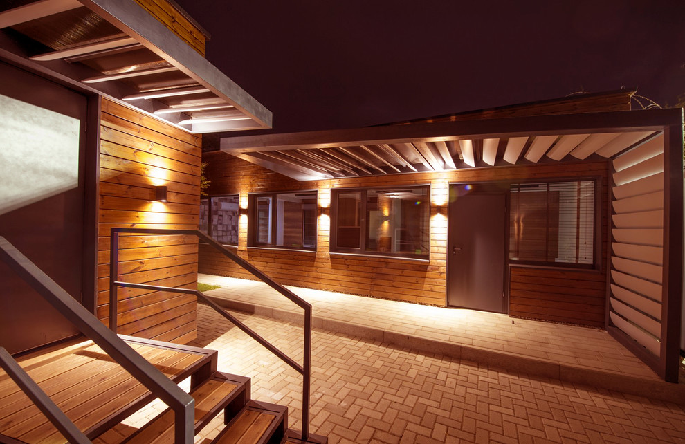 Einstöckiges Modernes Haus mit brauner Fassadenfarbe, Flachdach und Blechdach in Sonstige
