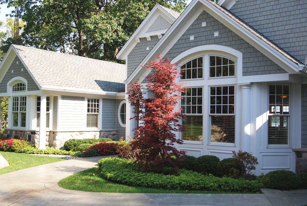 Design ideas for a gey traditional two floor house exterior in Grand Rapids with wood cladding.