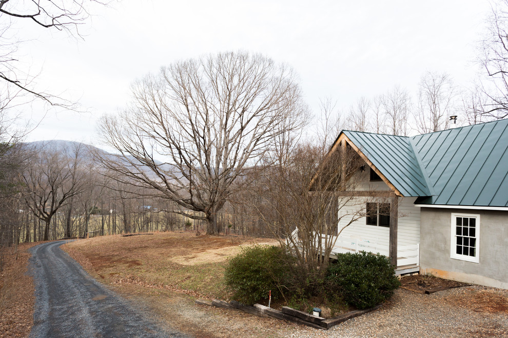 Kleines, Einstöckiges Country Haus mit Betonfassade, grauer Fassadenfarbe und Satteldach in Sonstige