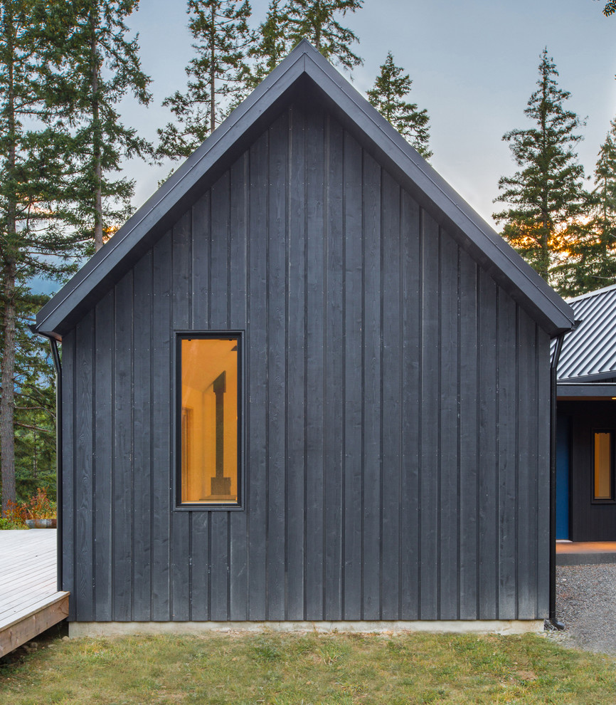На фото: маленький, одноэтажный, деревянный, серый дом в стиле рустика с двускатной крышей для на участке и в саду с