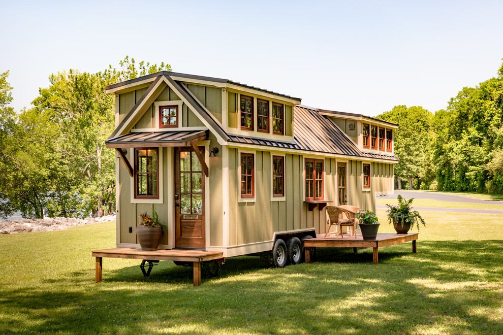 Immagine della micro casa piccola verde classica a un piano con rivestimento in legno, tetto a capanna e copertura in metallo o lamiera