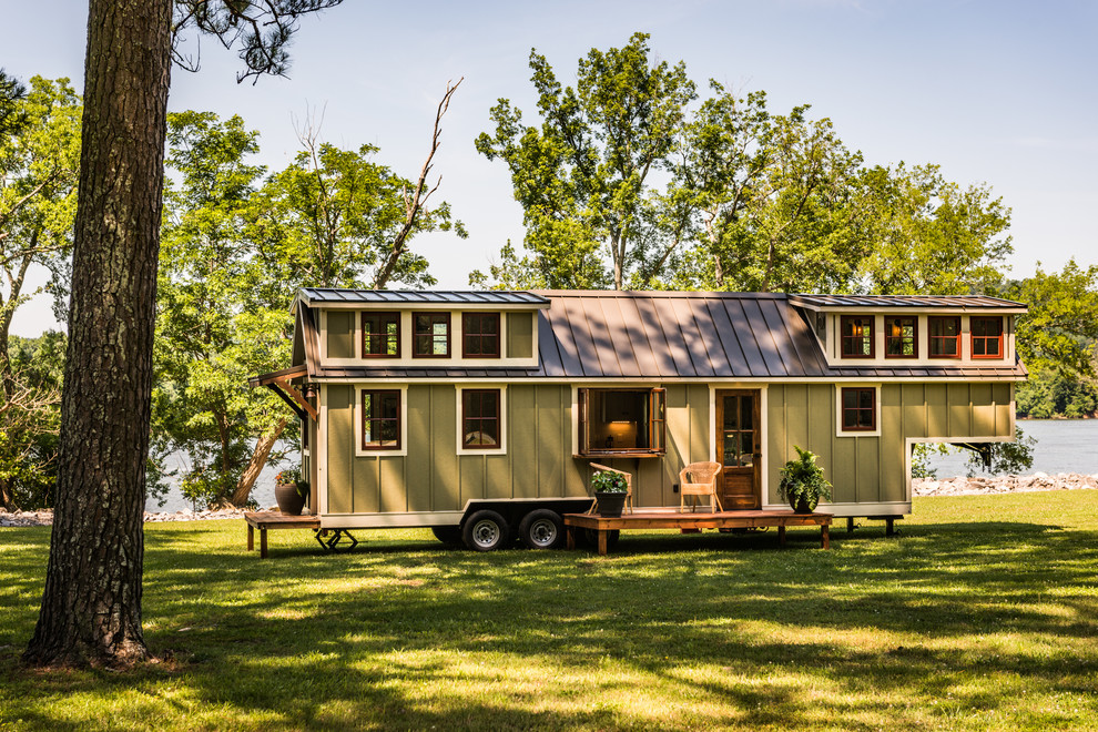 Immagine della villa piccola verde american style a due piani con rivestimento in legno, tetto a capanna e copertura in metallo o lamiera