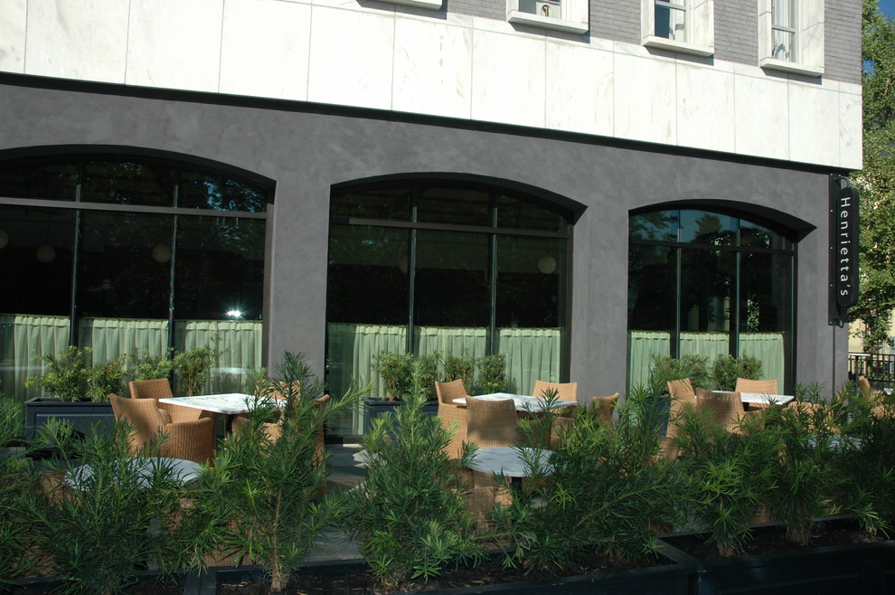 Imagen de fachada gris retro extra grande de tres plantas con revestimiento de ladrillo