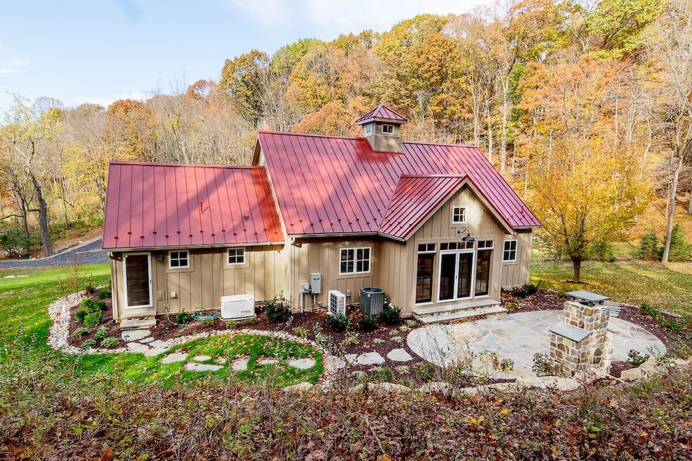 Réalisation d'une façade de maison marron chalet en bois de taille moyenne et à un étage avec un toit à deux pans et un toit en métal.