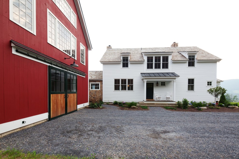 Immagine della facciata di una casa grande rossa classica a due piani con rivestimento in legno e tetto a capanna