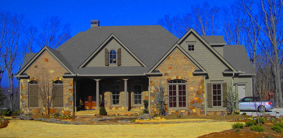 Cette image montre une façade de maison multicolore traditionnelle de taille moyenne et à un étage avec un revêtement mixte et un toit à deux pans.
